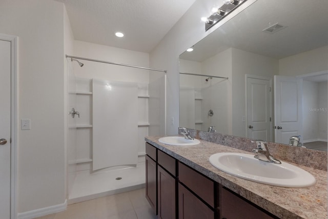 bathroom featuring a shower, tile patterned floors, vanity, and a textured ceiling