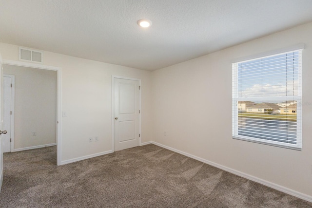 unfurnished bedroom with carpet floors and a textured ceiling