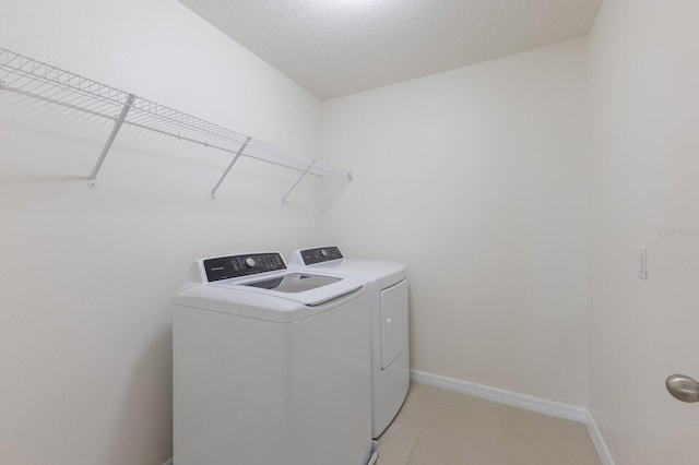 washroom featuring light tile patterned flooring and washing machine and dryer