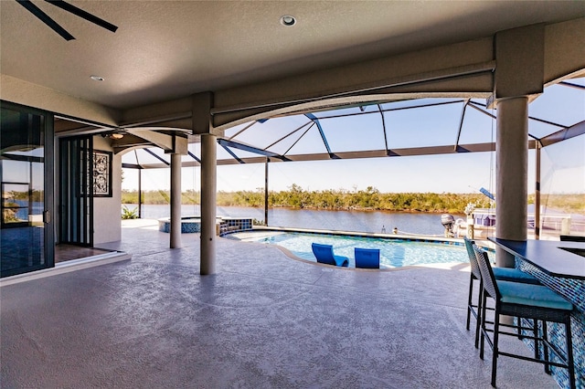 view of pool featuring ceiling fan, a water view, a patio, and exterior bar