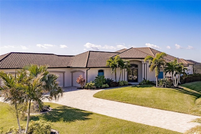 mediterranean / spanish-style home with a garage and a front lawn