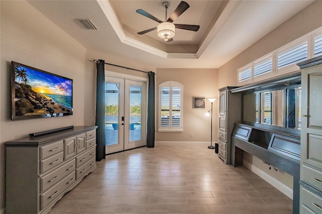 doorway to outside featuring a tray ceiling, ceiling fan, and french doors