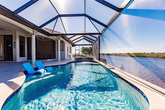 view of swimming pool featuring glass enclosure, a water view, pool water feature, a patio, and a hot tub