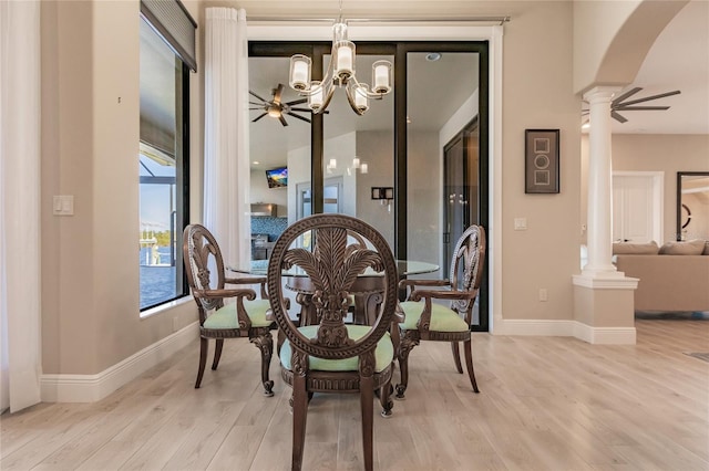 dining area with decorative columns, ceiling fan with notable chandelier, and light wood-type flooring