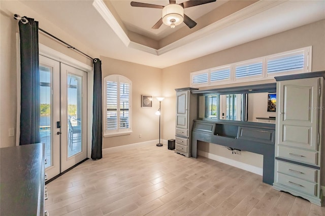 miscellaneous room featuring french doors, light hardwood / wood-style floors, a raised ceiling, and ceiling fan