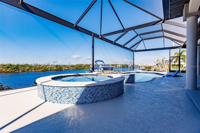 view of swimming pool featuring a lanai, a patio area, an in ground hot tub, and a water view