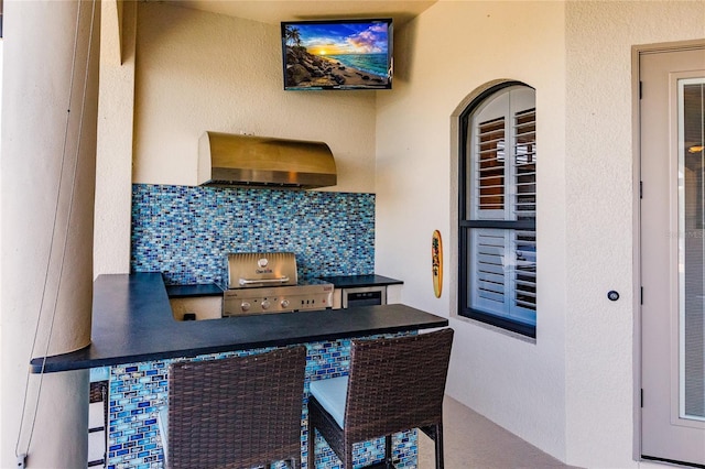 interior space featuring decorative backsplash and wall chimney range hood