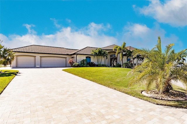 mediterranean / spanish-style house featuring a garage and a front yard