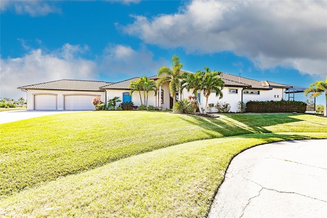 mediterranean / spanish house with a garage and a front lawn