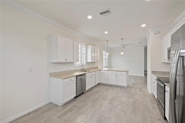 kitchen with sink, kitchen peninsula, hanging light fixtures, appliances with stainless steel finishes, and white cabinetry