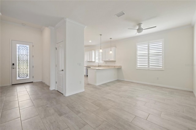 interior space with white cabinetry, ceiling fan, kitchen peninsula, decorative light fixtures, and ornamental molding