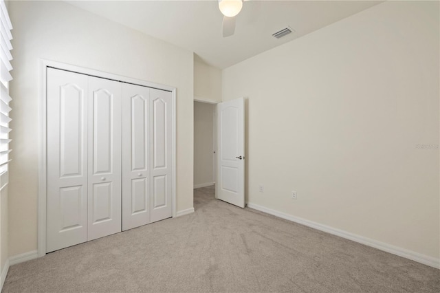 unfurnished bedroom with light carpet, a closet, and ceiling fan