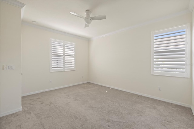 carpeted spare room featuring ceiling fan, ornamental molding, and a wealth of natural light