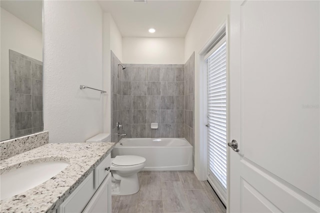 full bathroom featuring vanity, toilet, and tiled shower / bath