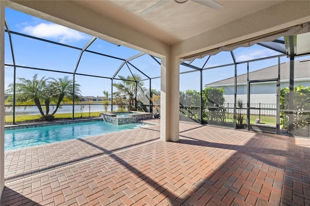 view of swimming pool with glass enclosure, a water view, ceiling fan, an in ground hot tub, and a patio area