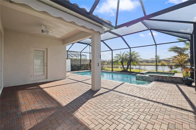 view of pool with ceiling fan, a lanai, a patio area, an in ground hot tub, and a water view