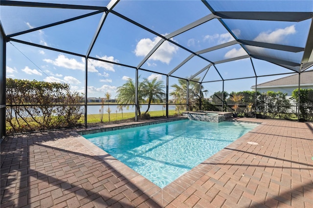 view of pool with glass enclosure, a patio area, a water view, and an in ground hot tub