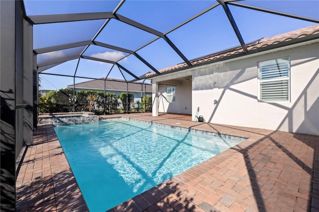 view of swimming pool featuring glass enclosure, an in ground hot tub, and a patio