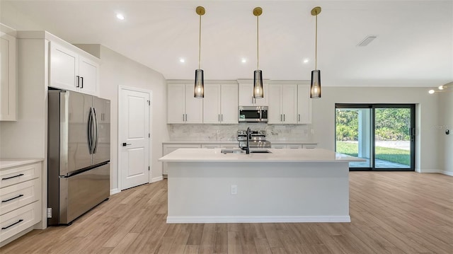 kitchen featuring pendant lighting, a center island with sink, white cabinetry, and appliances with stainless steel finishes