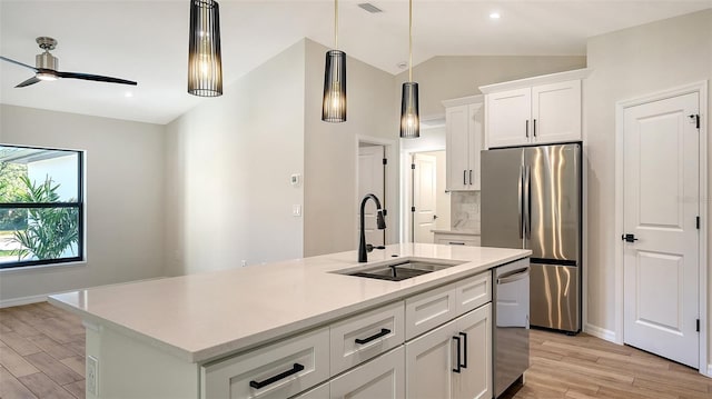 kitchen with a center island with sink, sink, decorative light fixtures, white cabinetry, and stainless steel appliances