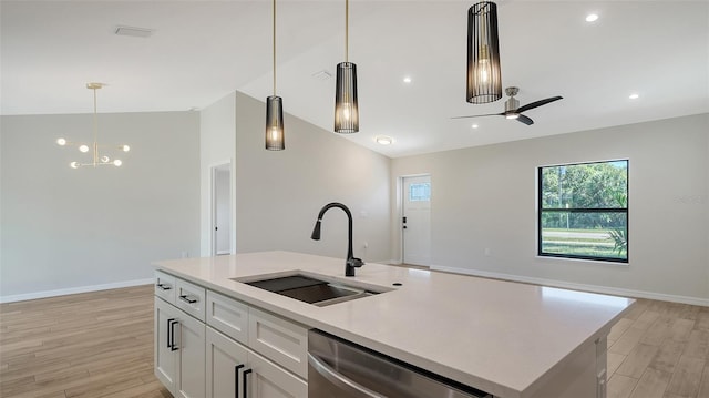 kitchen featuring a center island with sink, ceiling fan with notable chandelier, sink, stainless steel dishwasher, and white cabinetry