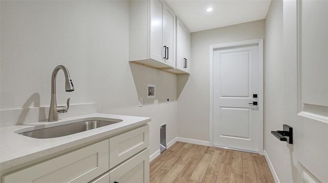 washroom featuring sink, cabinets, washer hookup, electric dryer hookup, and light hardwood / wood-style flooring