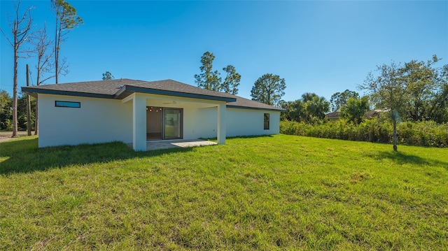 back of house featuring a yard and a patio area