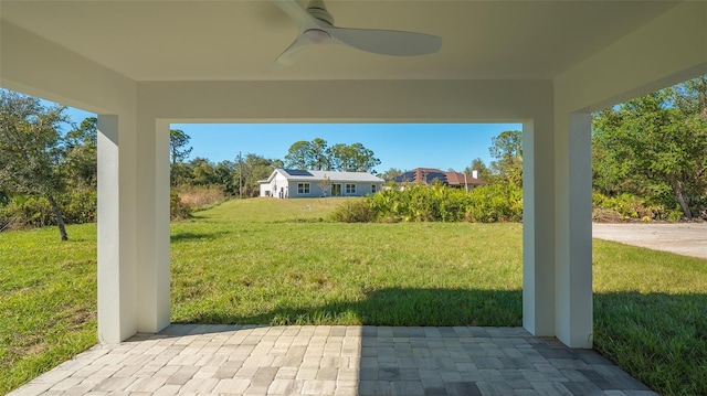 view of yard featuring ceiling fan and a patio