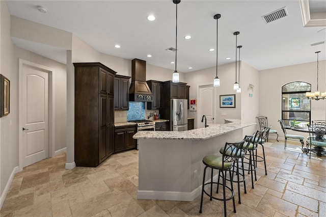 kitchen with pendant lighting, a breakfast bar, an inviting chandelier, appliances with stainless steel finishes, and custom range hood