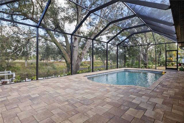 view of swimming pool with glass enclosure and a patio area