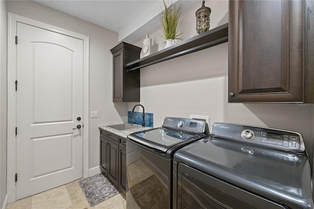 washroom featuring cabinets, washing machine and dryer, and sink