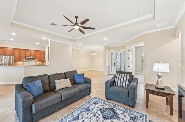 living room featuring a tray ceiling, ceiling fan, crown molding, and light tile patterned flooring