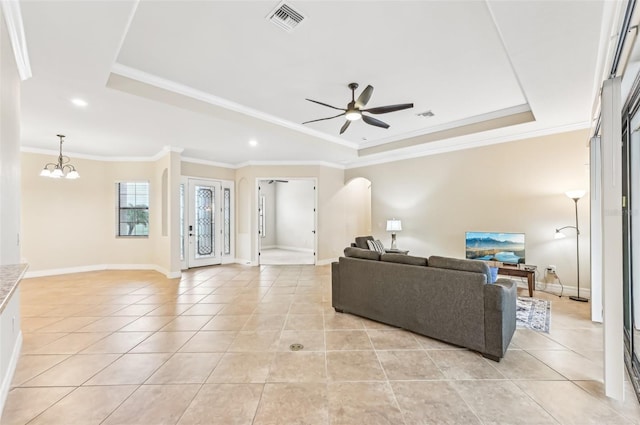 tiled living room with a tray ceiling, crown molding, and ceiling fan with notable chandelier