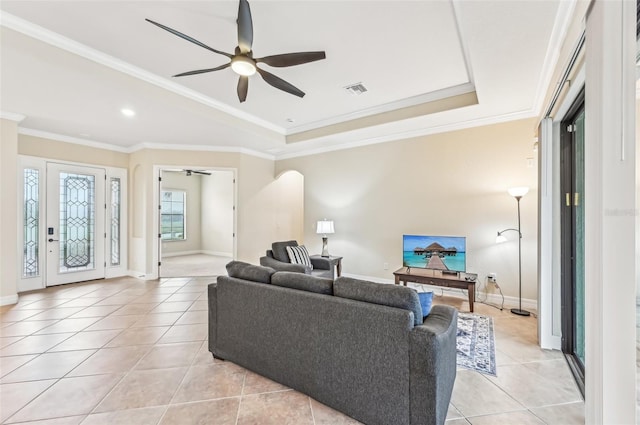 tiled living room with ceiling fan and ornamental molding