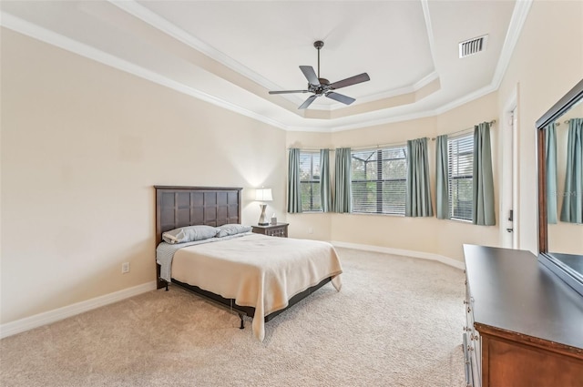 bedroom with a raised ceiling, ceiling fan, light carpet, and ornamental molding