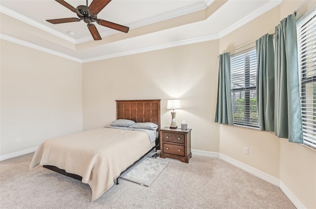 carpeted bedroom featuring a raised ceiling, ceiling fan, and ornamental molding