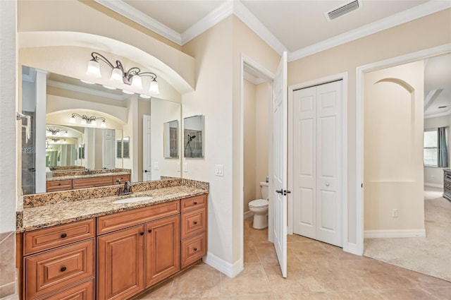 bathroom featuring tile patterned flooring, toilet, vanity, and ornamental molding