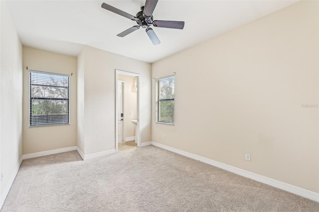 unfurnished bedroom featuring ceiling fan, light carpet, and multiple windows