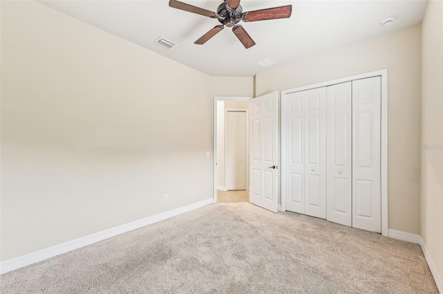 unfurnished bedroom featuring ceiling fan, light carpet, and a closet