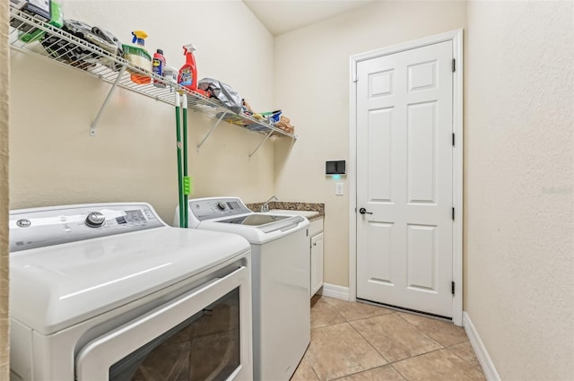 washroom featuring washer and dryer, light tile patterned flooring, cabinets, and sink