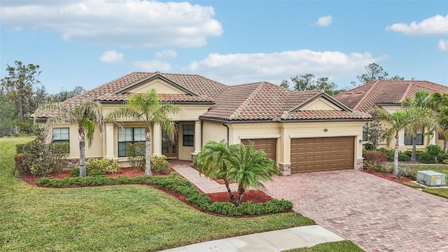 mediterranean / spanish home with a garage and a front lawn