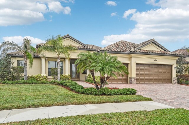 mediterranean / spanish house featuring a garage and a front yard