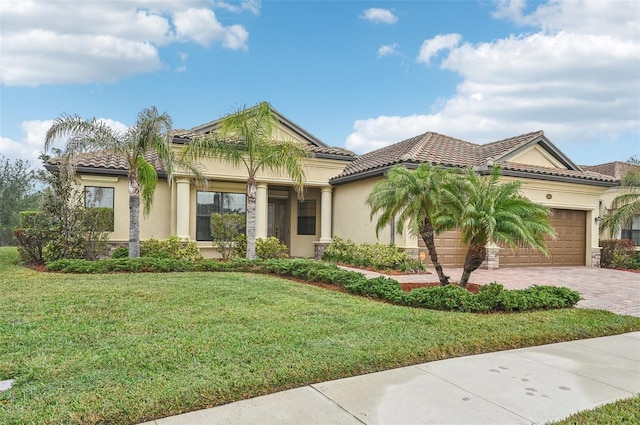 mediterranean / spanish-style home featuring a front yard and a garage