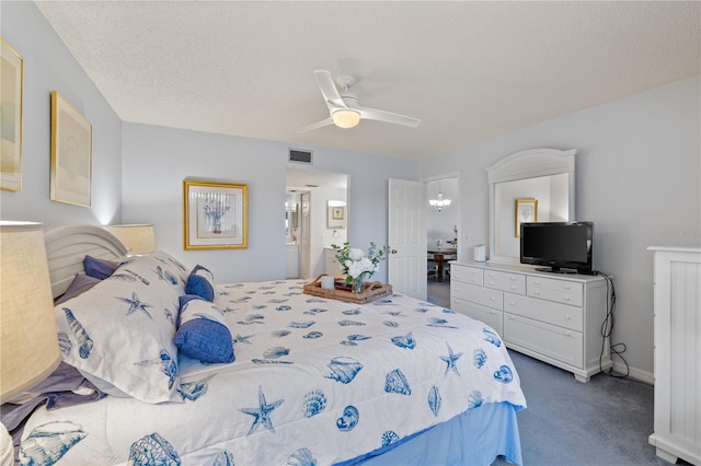 carpeted bedroom with ceiling fan and a textured ceiling