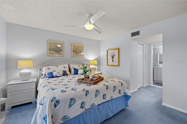 carpeted bedroom with ceiling fan, a textured ceiling, connected bathroom, and a closet