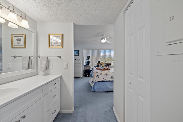 bathroom featuring ceiling fan, vanity, and a textured ceiling