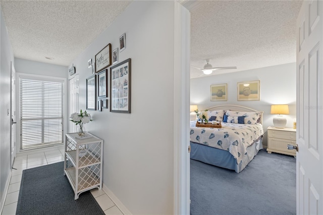 bedroom featuring a textured ceiling, tile patterned floors, and ceiling fan