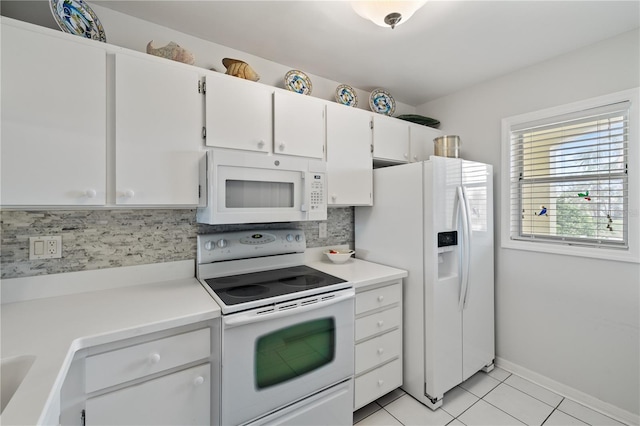 kitchen with light tile patterned floors, white appliances, white cabinetry, and backsplash