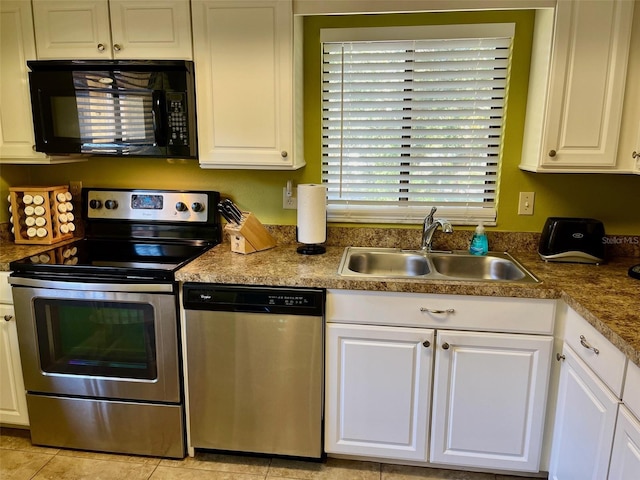 kitchen with white cabinets, sink, light tile patterned floors, and stainless steel appliances