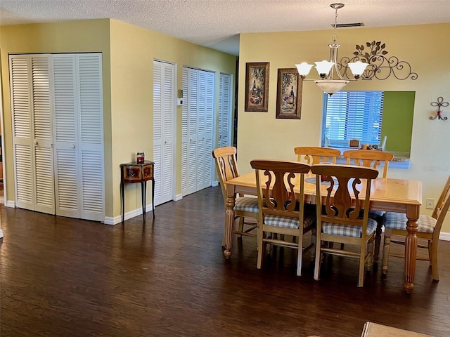 dining space featuring a chandelier, a textured ceiling, and dark hardwood / wood-style floors